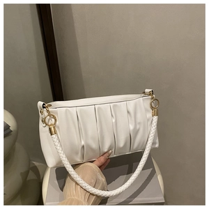 Detail of white pleated cloud bag showing woven strap and gold metal ring buckle