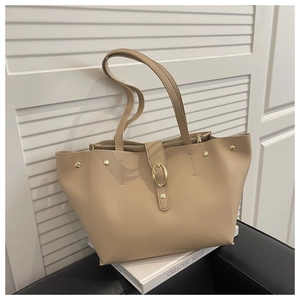 Detail view of khaki PU leather tote bag with gold buckle and rivet accents