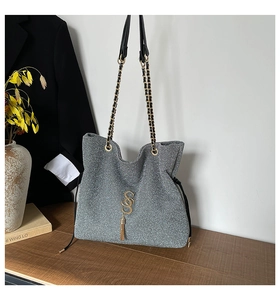 Détail du sac bandoulière argenté à paillettes avec chaîne et pompon en cuir
