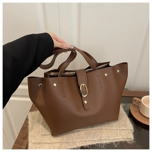 Close-up of brown soft leather bucket bag with golden buckle and zipper detail
