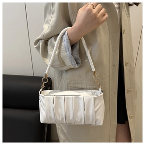 Detail of white pleated shoulder bag with woven handle and gold metal ring link