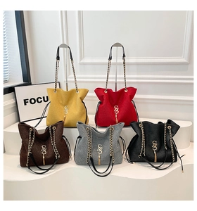 Detail von Glitzer-Tote-Bags in fünf Farben mit Gold-Logo und Quasten-Anhänger