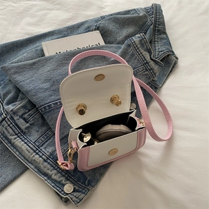 Mini pink and white cartoon handbag for girls on blue denim jacket with daily essentials