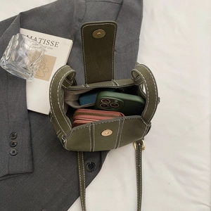 Olive green bucket bag in pebble leather featuring contrast stitching and inner storage