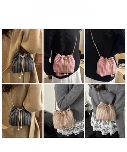 Woven bucket bag with gold chain and pearl charms shown on models in three colors