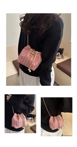 Detail of pink woven bucket bag with pearl drawstring tassels and gold chain strap