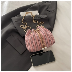 Detailed shot of pink tweed bucket bag with gold chain strap and pearl drawstring charm
