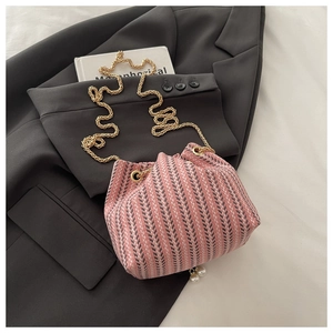 Detail of pink and grey knitted bucket bag with arrow patterns and golden chain strap