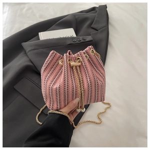 Detail of pink and white tweed bucket bag with gold chain and pearl drawstring charms