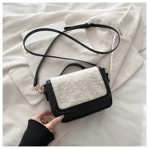 Detail of a vintage plush saddle bag featuring black leather and white faux shearling texture