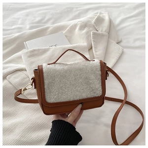 Detail of plush faux fur and brown leather texture on the vintage saddle shoulder bag