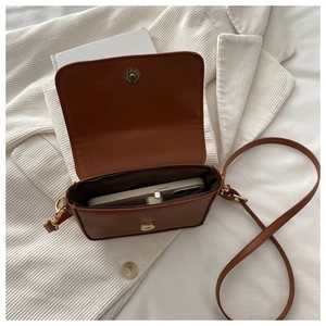 Detail view of brown leather saddle bag interior with phone showing storage capacity