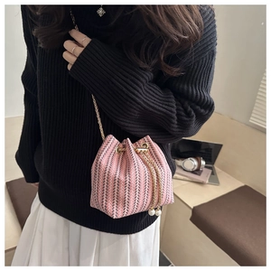 Detail of pink and grey knitted bucket bag with gold chain strap and pearl accents