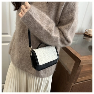Detail view of retro plush saddle bag with faux fur flap worn with an autumn outfit