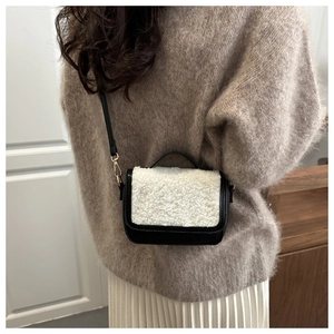 Detail of a vintage plush saddle bag showing black leather and white faux shearling texture