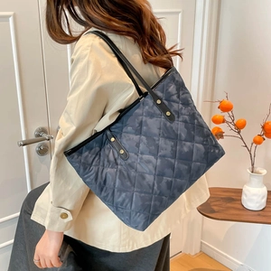 Stylish large quilted tote bag with dark camouflage pattern and leather straps
