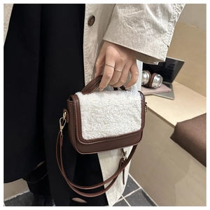 Detail of vintage saddle bag with brown PU leather and white plush fleece flap contrast