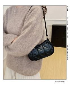 Detail of black geometric quilted hobo bag with sleek shoulder strap on model