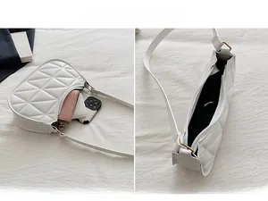 Detail of white quilted half-moon shoulder bag showing interior space and geometric texture