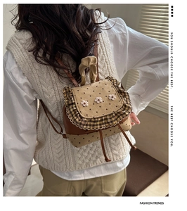 Detailed back view of a khaki polka dot backpack with ruffled edges and floral accents