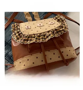 Detail view of brown PU backpack with floral 3D accents and polka dot fabric stitching