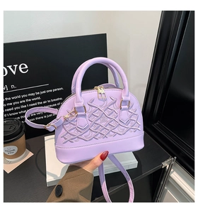 Close-up of lavender shell bag with intricate embroidery and elegant gold hardware