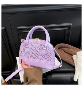 Detailed close-up of lavender embroidered shell handbag with wavy quilted patterns