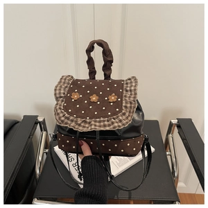 Close-up of a mini patchwork backpack with floral accents and polka dot fabric texture