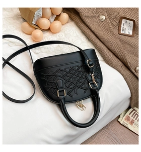 Detail of black shell crossbody bag with geometric embroidery and gold hardware