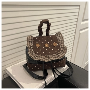 Detailed view of floral backpack featuring polka dot fabric and decorative ruffled edges