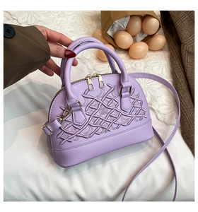 Detailed embroidery texture on lavender shell-shaped handbag with golden hardware