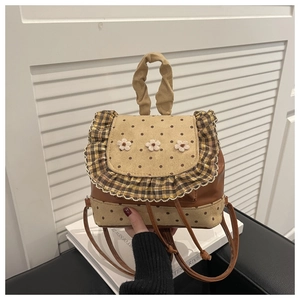 Detailed view of the vintage floral lace trim and embroidery on the retro brown backpack