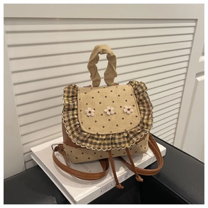 Detailed view of floral embroidery and polka dot patterns on retro brown backpack