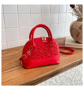 Macro detail of red shell bag featuring intricate diamond embroidery and gold hardware