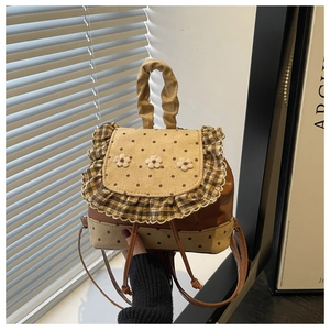 Detail of floral embroidery and polka dot patterns on a vintage-style mini backpack