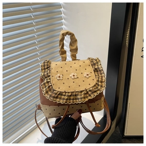 Detail of sweet floral mini backpack featuring polka dot flap and woven flower accents