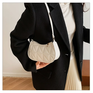 Quilted white shoulder bag styled with a black blazer for a minimalist chic look