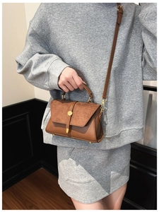 Braune Umhängetasche aus Leder und Wildleder mit goldener Schnalle am Model
