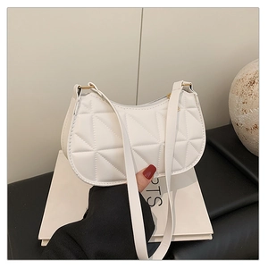 Detail of white quilted half-moon shoulder bag with geometric pattern and gold zipper