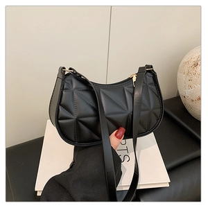 Detailed close-up of black quilted geometric texture on a stylish crescent shoulder bag