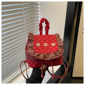 Detail of red floral leather mini backpack with white polka dots and ruffled plaid trim