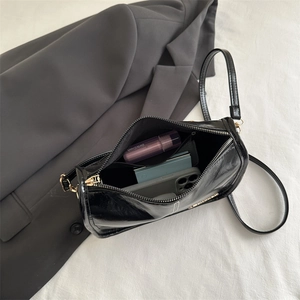 Sac à bandoulière noir brillant minimaliste avec détails dorés et intérieur spacieux