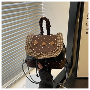 Detail of floral sweet backpack featuring brown polka dot fabric and plush 3D flower accents