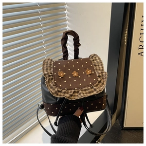 Detail of vintage flower backpack featuring polka dot flap and pleated fabric handle