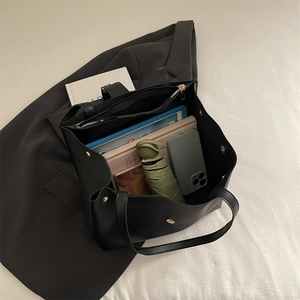 Large black minimalist tote bag with internal compartments shown with commute essentials