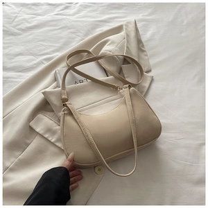 Detail of cream matte shoulder bag featuring textured faux leather and adjustable gold buckle