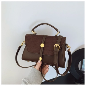 Nahaufnahme einer vintage dunkelbraunen matten Handtasche mit goldener Schnalle und Griff
