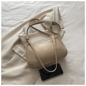 Chic beige crossbody bag with adjustable strap shown next to a phone for size scale