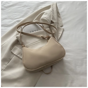 Beige matte hobo shoulder bag with sleek leather strap on neutral textured fabric