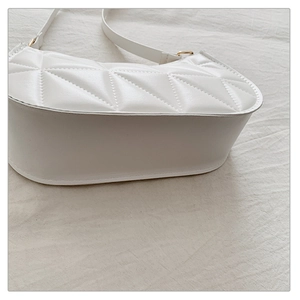 Detail view of white quilted PU leather handbag base with adjustable gold buckle